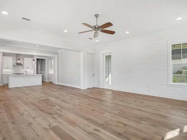 a view of empty room with wooden floor and window