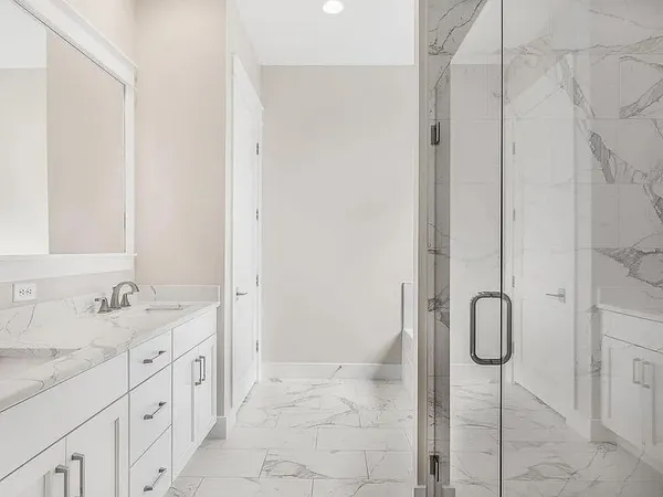 a spacious bathroom with a granite countertop sink and a shower