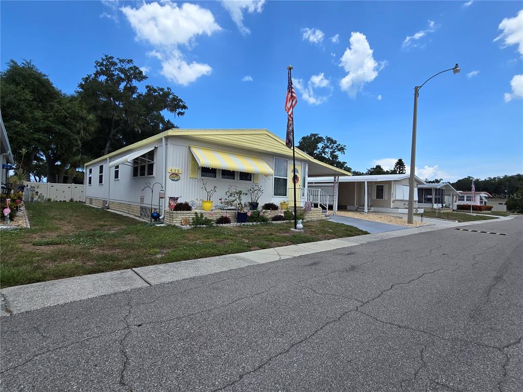 5619 Bayshore Road, Unit 435 Palmetto, FL 34221 - Photo 42 of 56 a view of a white house with a big yard and large trees
