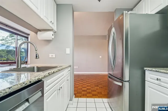 a kitchen with granite countertop a refrigerator and a sink