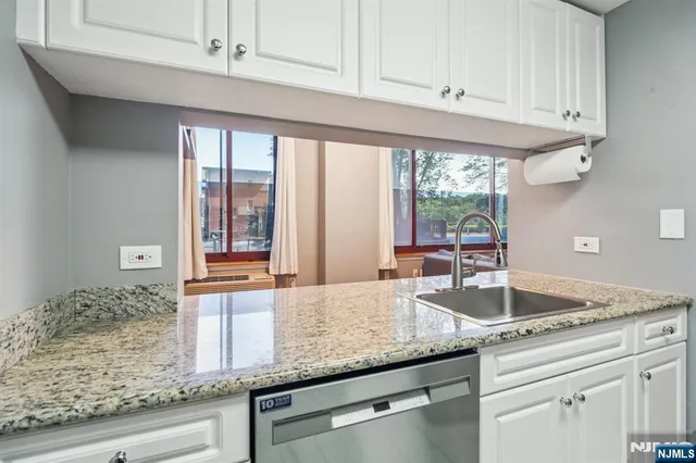 a kitchen with granite countertop a sink and a window