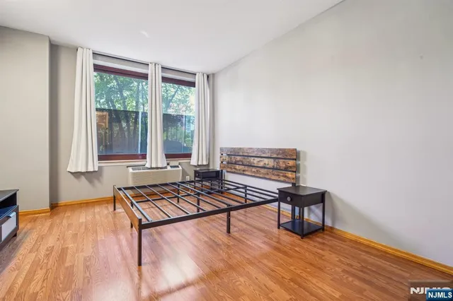 a living room with furniture a wooden floor and next to a window
