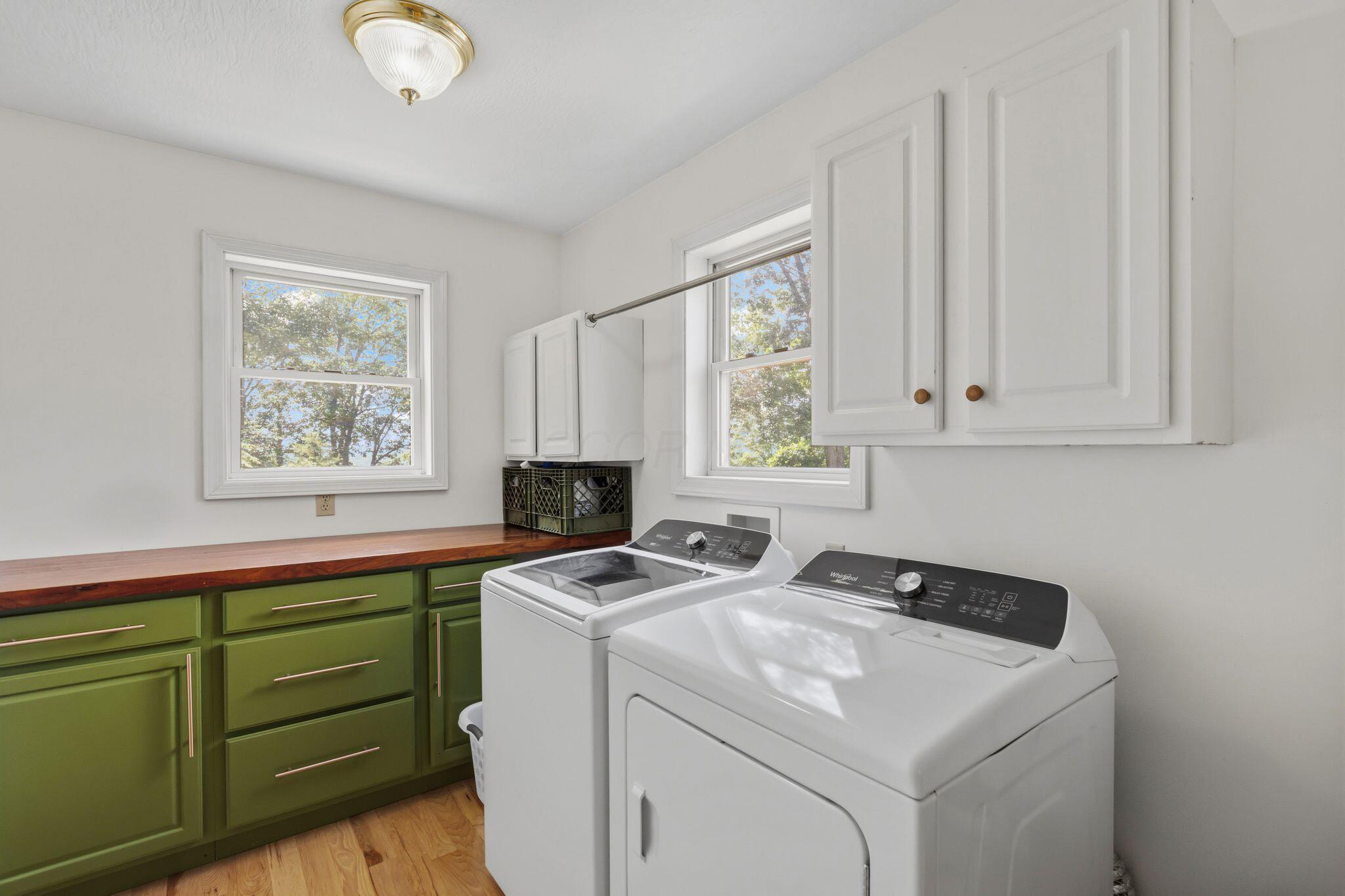 10446 Rich Hollow Road Southwest Lancaster, OH 43130 - Photo 23 of 83 Laundry room featuring wood-finish flooring, white walls, and a built-in countertop with green base cabinetry