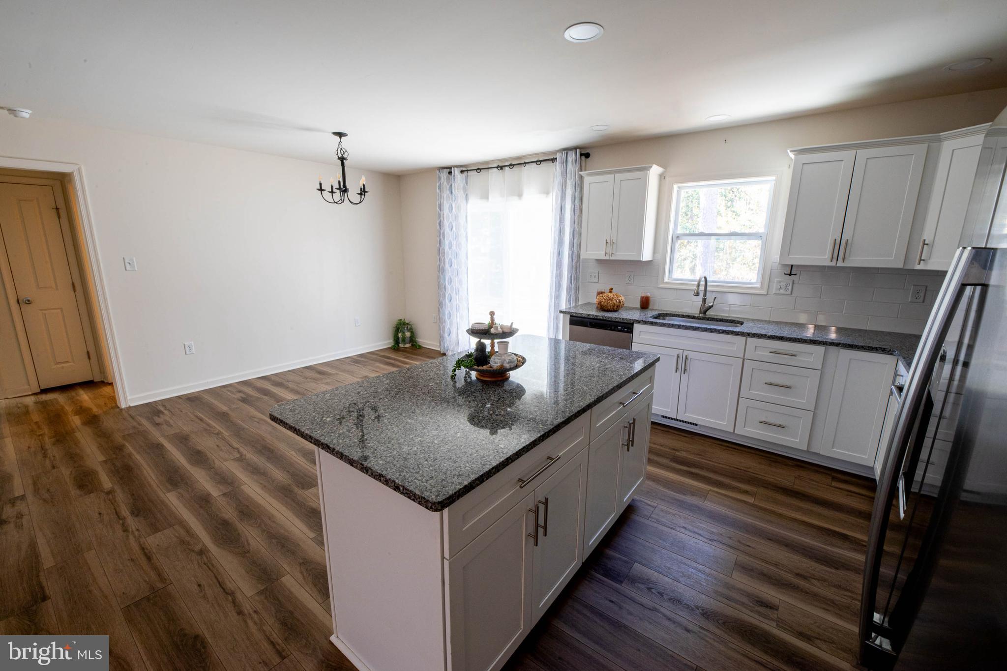 26300 Fire Tower Road Seaford, DE 19973 - Photo 11 of 52 a kitchen with sink cabinets and wooden floor
