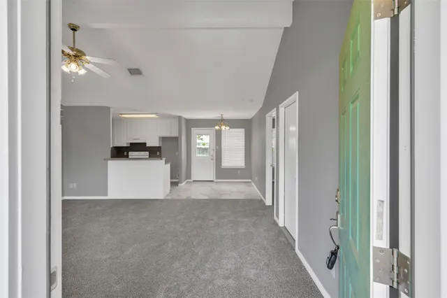 a view of a hallway with wooden floor and a living room