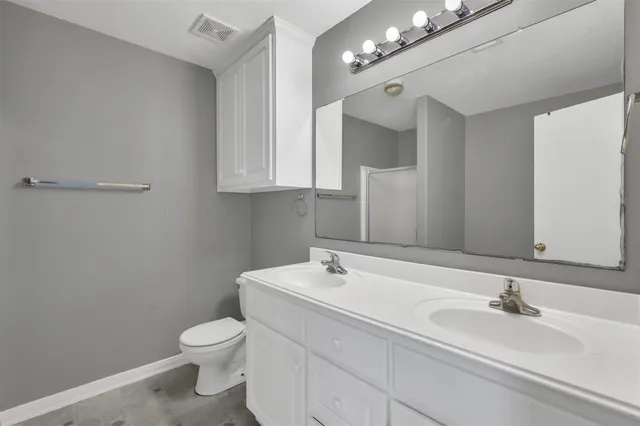 a bathroom with a sink vanity granite and toilet