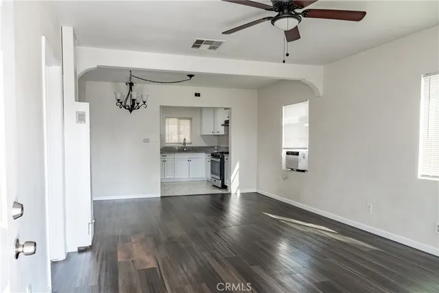 a view of empty room with wooden floor and window