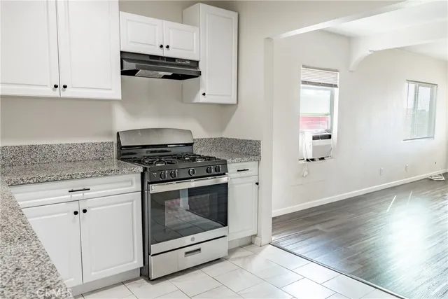 a kitchen with granite countertop white cabinets and appliances