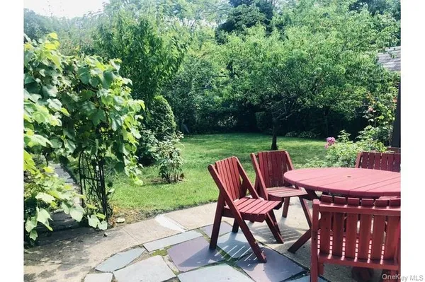 a view of a chairs and table in backyard