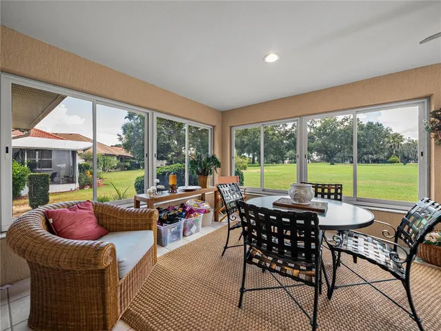 a living room with furniture and floor to ceiling windows