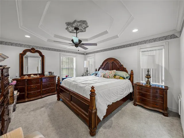 a bed sitting in a bedroom next to a window and a chandelier