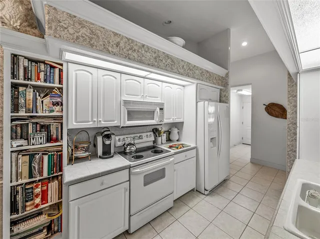 a kitchen with stainless steel appliances a refrigerator and a book shelf