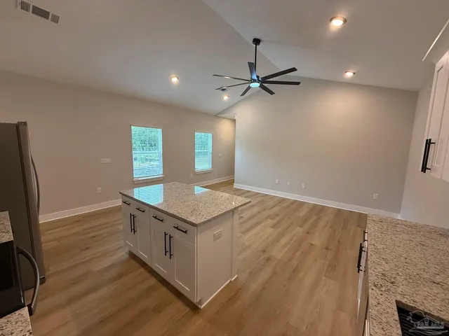 an empty room with a window and a ceiling fan