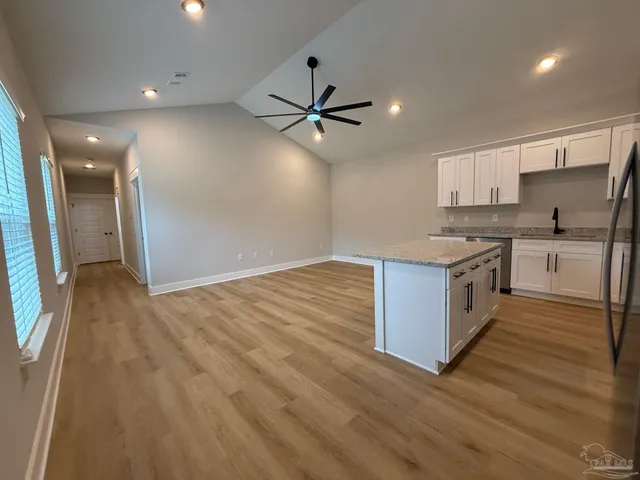 a large kitchen with kitchen island a sink stainless steel appliances and cabinets