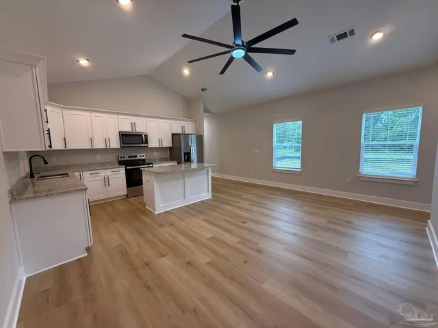 a kitchen with a refrigerator a sink and a microwave