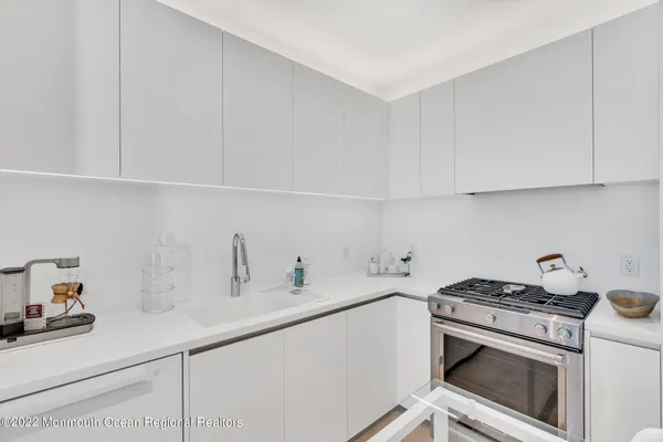 a kitchen with white cabinets and white appliances