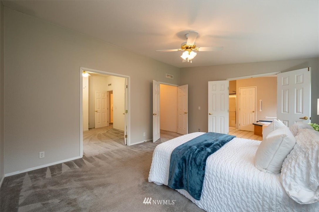 8259 Custer School Road Custer, WA 98240 - Photo 22 of 40 a spacious bedroom with a large bed and chandelier fan