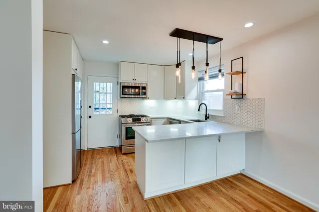 a kitchen with stainless steel appliances a sink stove and refrigerator