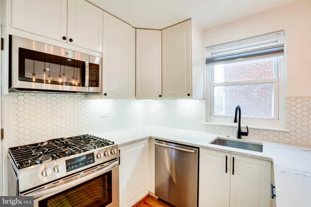 a kitchen with stainless steel appliances a stove a sink and a microwave