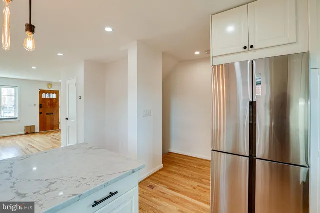 a view of a hallway with wooden floor and cabinet