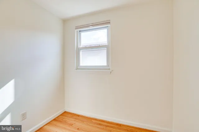 a view of a small space with wooden floor and a window