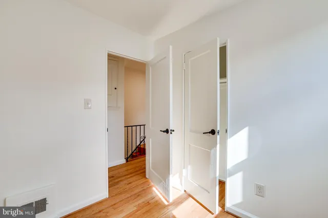 a view of a hallway with wooden floor and entryway