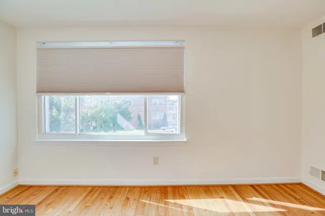 a view of a room with wooden floor and a window