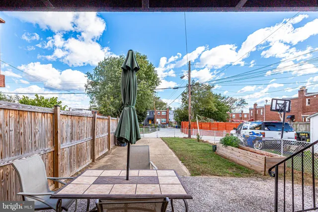 a view of a patio with table and chairs potted plants and large tree