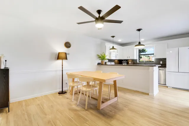 a kitchen with stainless steel appliances kitchen island granite countertop a sink a stove a dining table and chairs