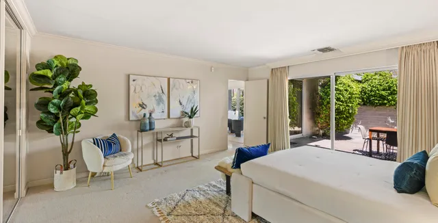 a living room with furniture a large window and a potted plant