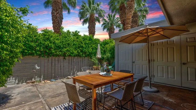 a backyard of a house with table and chairs
