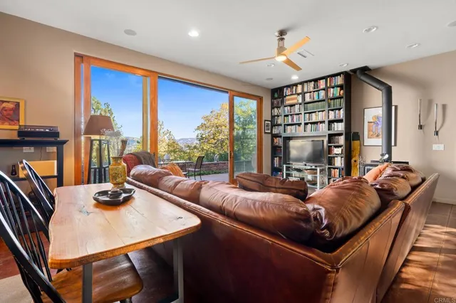 a dining hall with stainless steel appliances granite countertop a stove a refrigerator a dining table and chairs with wooden floor