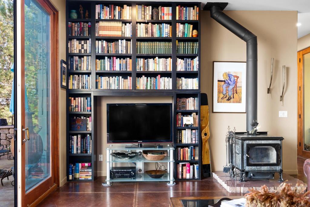 2810 3 Peaks Lane Julian, CA 92036 - Photo 19 of 54 a living room with fireplace furniture and a book shelf