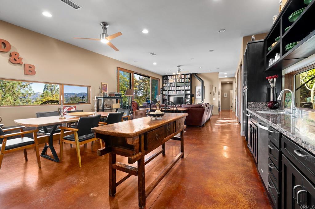 2810 3 Peaks Lane Julian, CA 92036 - Photo 20 of 54 a dining hall with stainless steel appliances granite countertop a stove a refrigerator a dining table and chairs with wooden floor