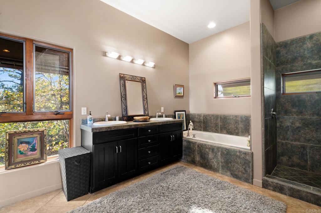 2810 3 Peaks Lane Julian, CA 92036 - Photo 37 of 54 a spacious bathroom with a tub sink shower and mirror