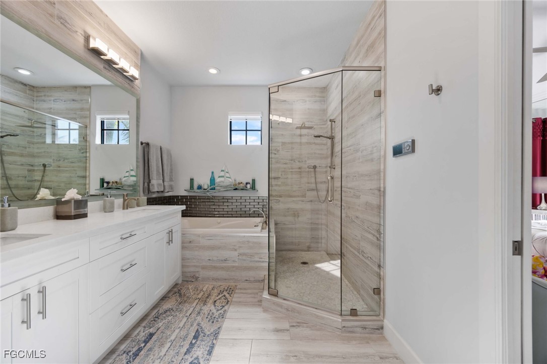 9111 Capistrano Street South, Unit 8302 Naples, FL 34113 - Photo 15 of 40 a spacious bathroom with a shower sink and mirror