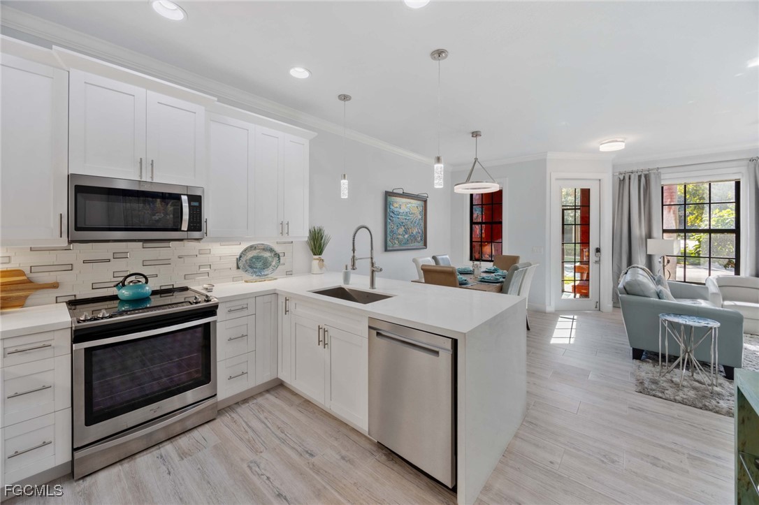 9111 Capistrano Street South, Unit 8302 Naples, FL 34113 - Photo 9 of 40 a kitchen with a sink stove and wooden floor