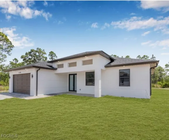 a front view of house with yard and garage