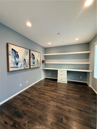 a view of empty room with wooden floor and fireplace