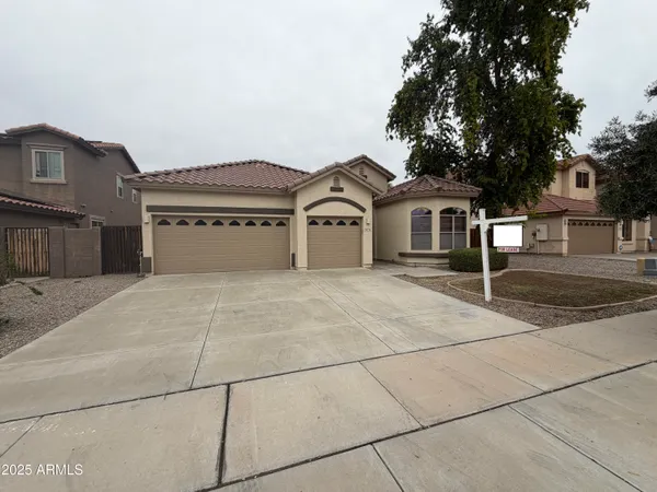 a front view of a house with a garden and trees