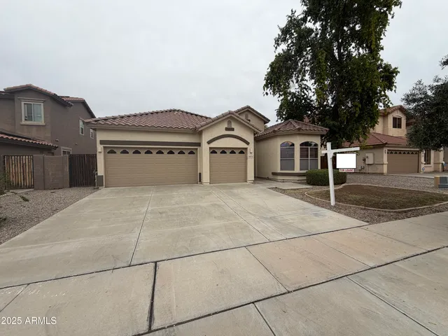 a front view of a house with a garden and trees