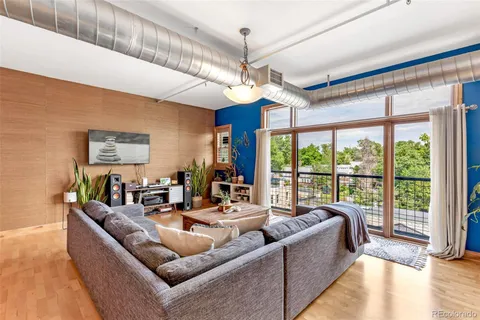 a living room with furniture ceiling fan and a large window