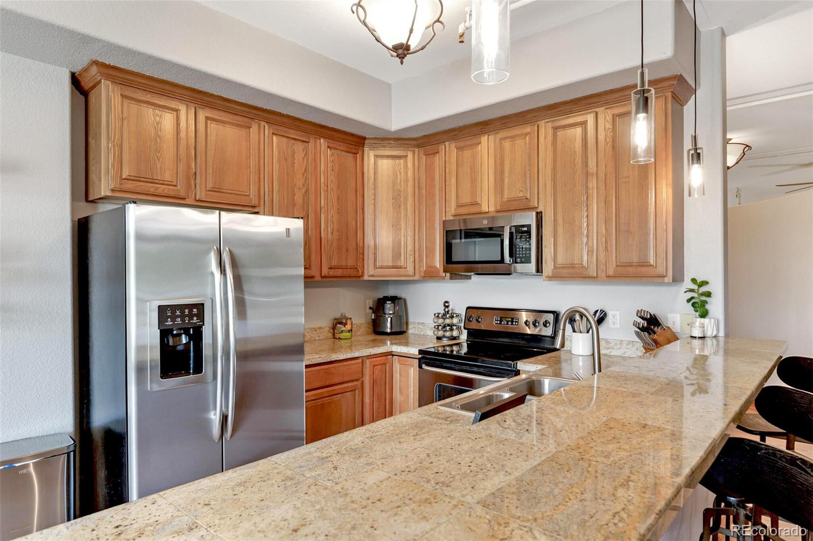 3299 Lowell Boulevard, Unit 302 Denver, CO 80211 - Photo 18 of 50 a kitchen with stainless steel appliances granite countertop a refrigerator a stove top oven a sink and dishwasher