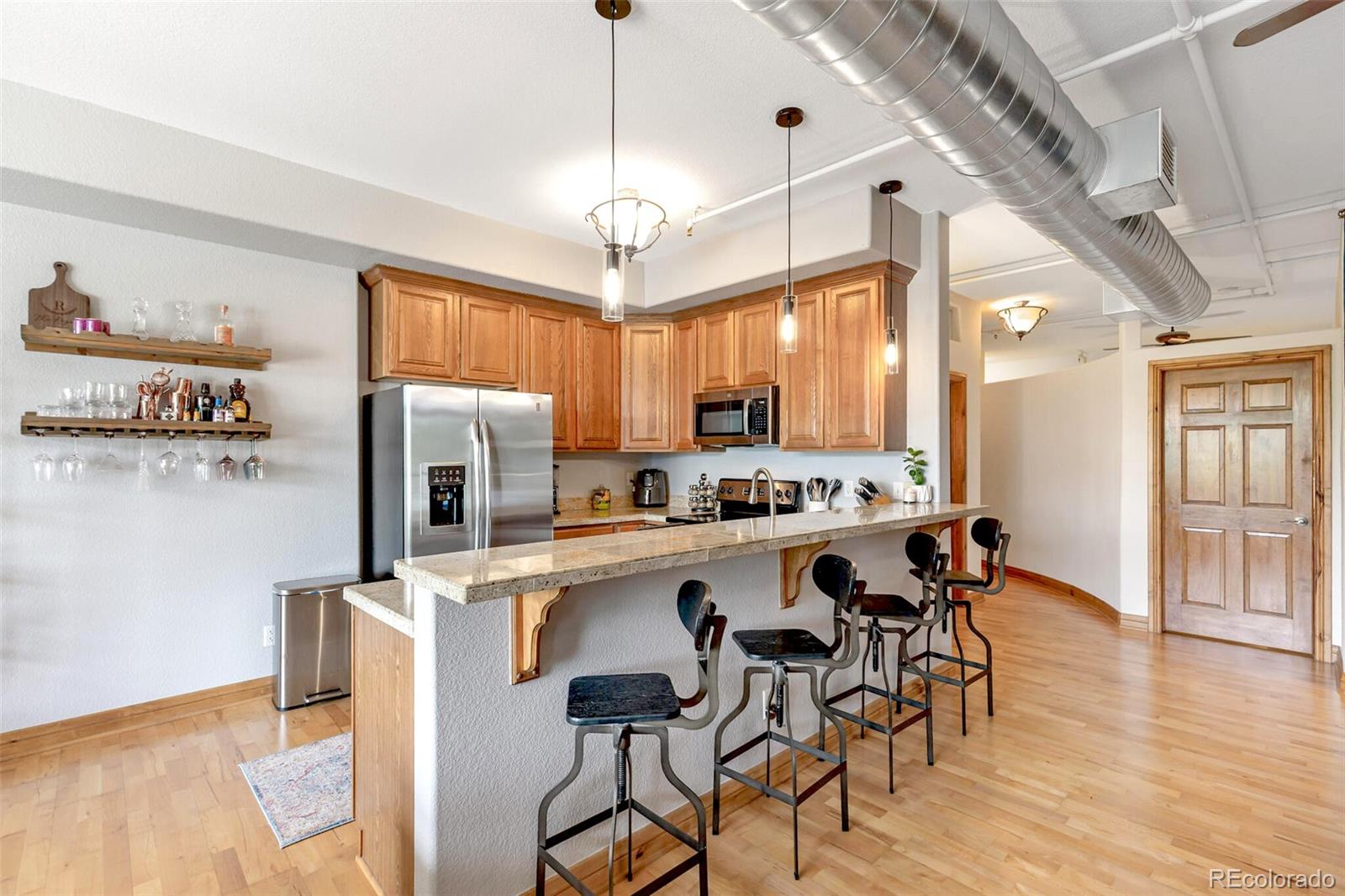 3299 Lowell Boulevard, Unit 302 Denver, CO 80211 - Photo 20 of 50 a kitchen with stainless steel appliances a dining table chairs refrigerator and sink