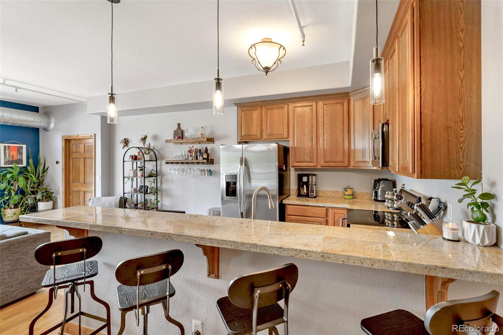 3299 Lowell Boulevard, Unit 302 Denver, CO 80211 - Photo 22 of 50 a kitchen with a dining table chairs sink and white cabinets