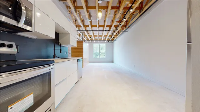 a view of a kitchen with stainless steel appliances granite countertop a stove and a microwave