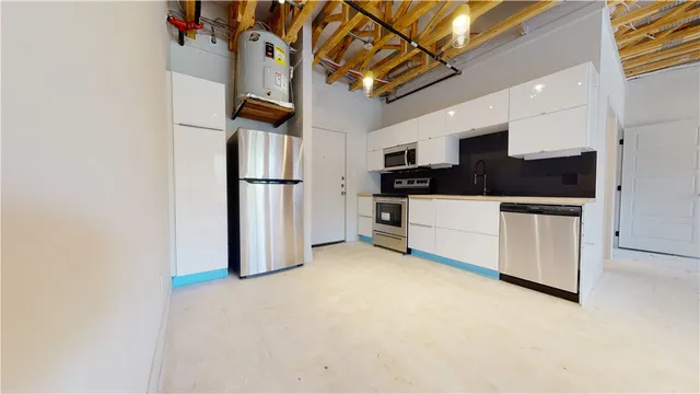 a kitchen with cabinets and steel appliances