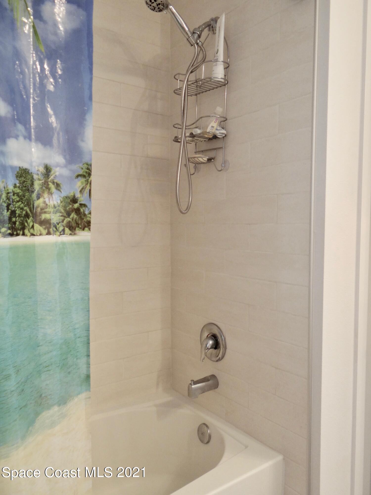 2725 Digby Road Southeast Palm Bay, FL 32909 - Photo 23 of 33 a bath tub sitting next to a white sink and a shower