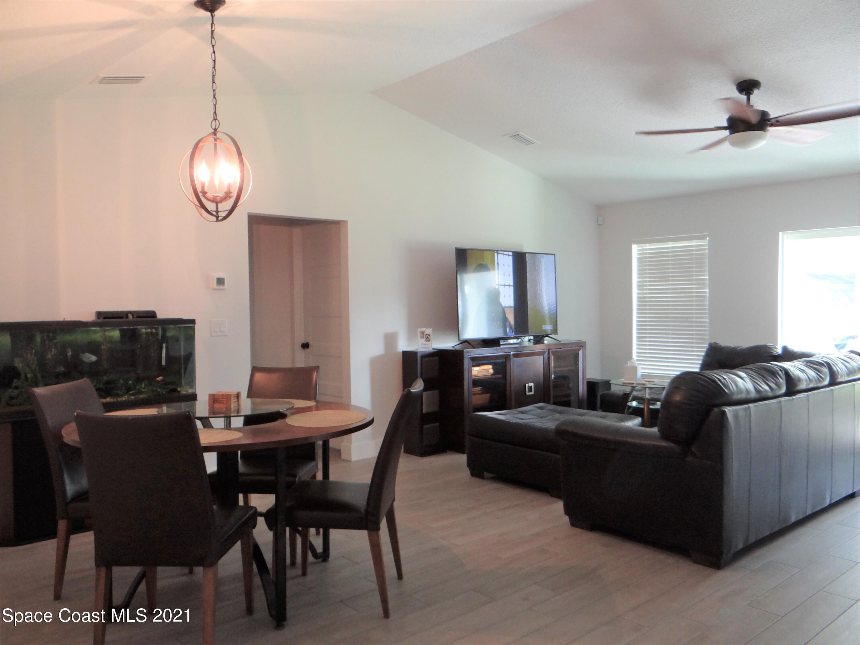 2725 Digby Road Southeast Palm Bay, FL 32909 - Photo 6 of 33 a living room with furniture a chandelier and a window