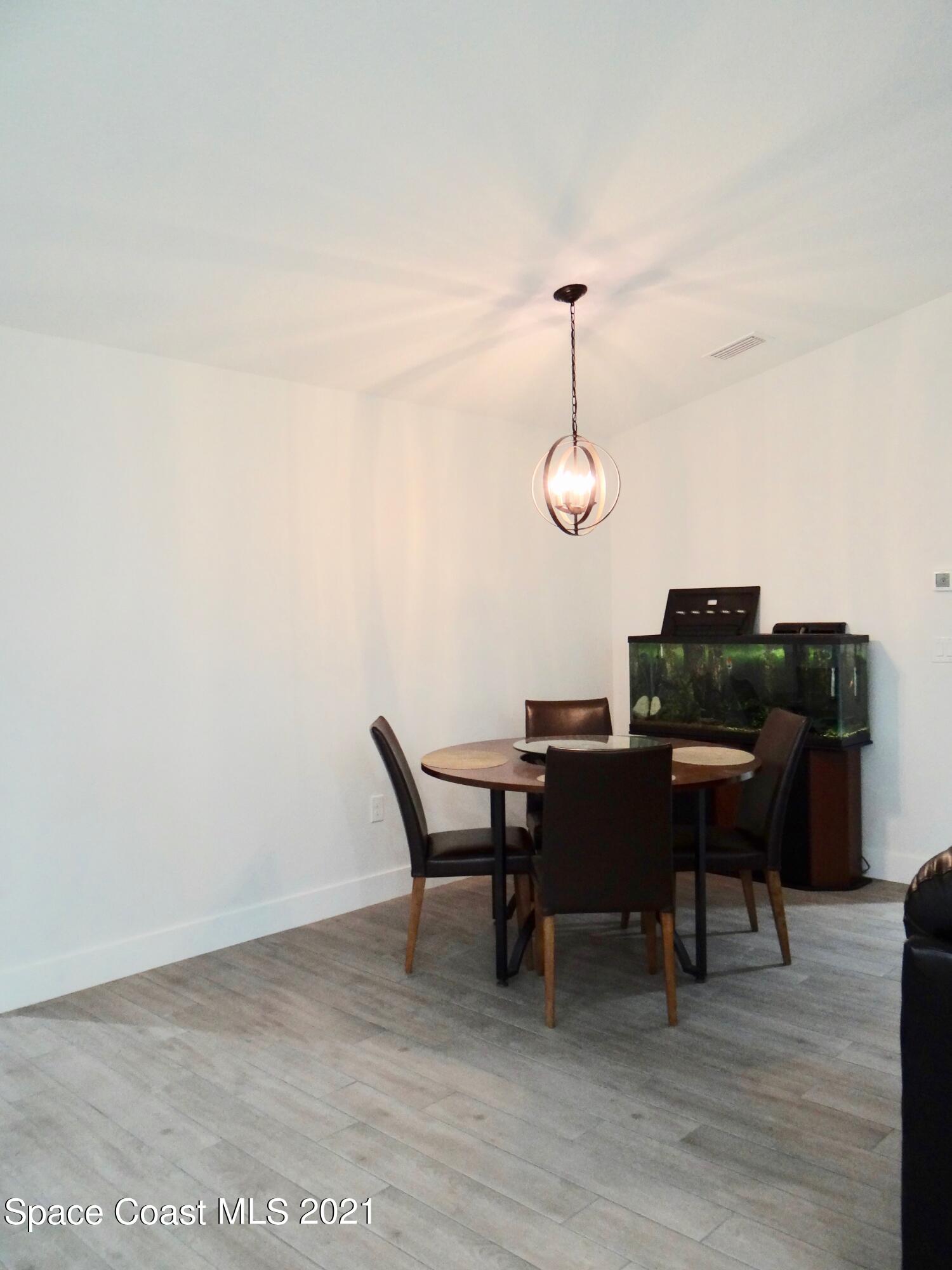 2725 Digby Road Southeast Palm Bay, FL 32909 - Photo 7 of 33 a view of a dining room with furniture and wooden floor
